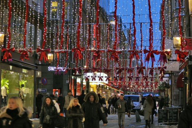 Människor på julpyntad shoppinggata i Stockholm